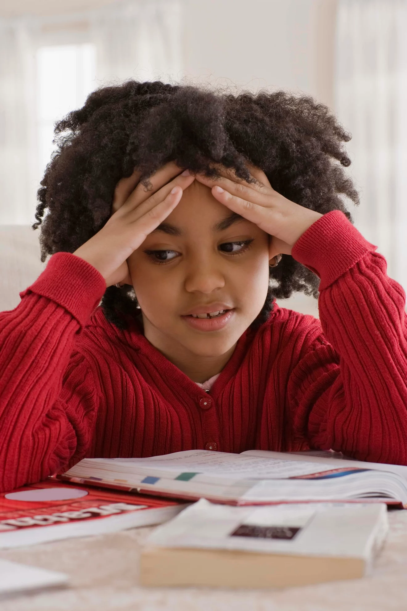 Fille accoudée à son bureau en classe devant ses cahiers